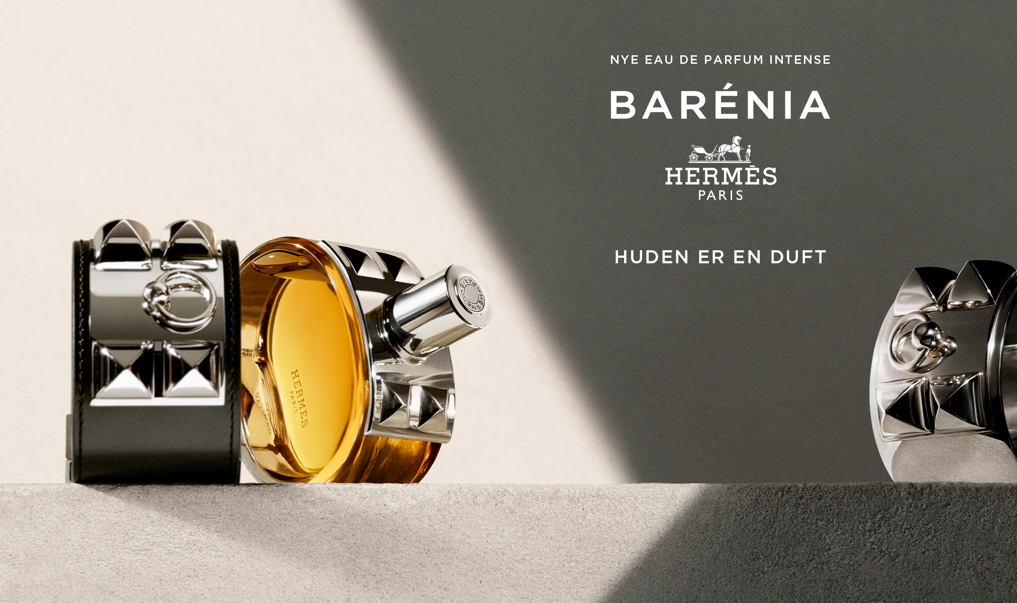 Hermès Barénia Eau de Parfum Intense-flaske, plassert på en overflate ved siden av et armbånd.