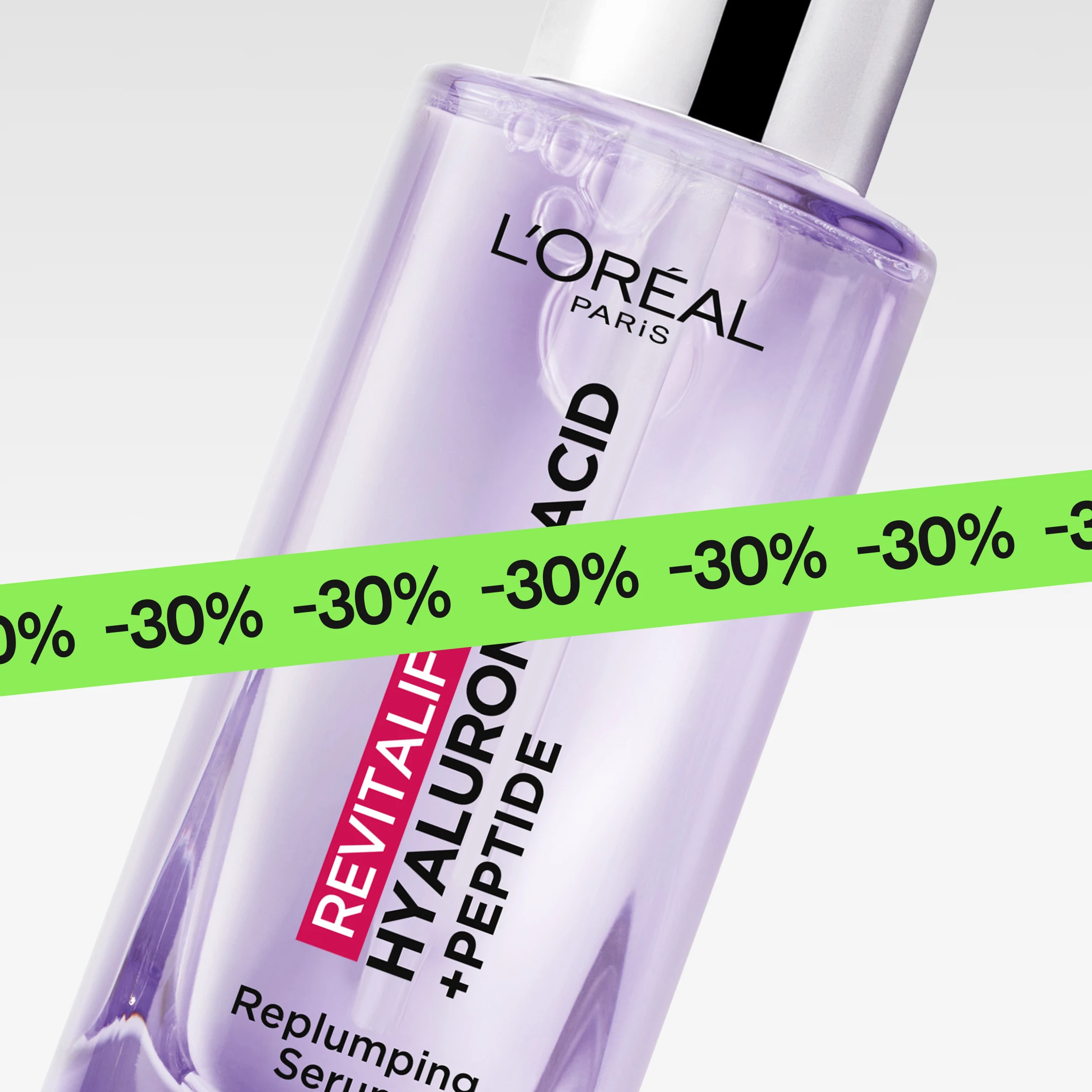 Lähikuva ihonhoitoseerumista “L’Oréal Paris Revitalift Hyaluronic Acid + Peptide Replumping Serum” violetissa pullossa, osittain vihreän “30%” -nauhan peitossa.