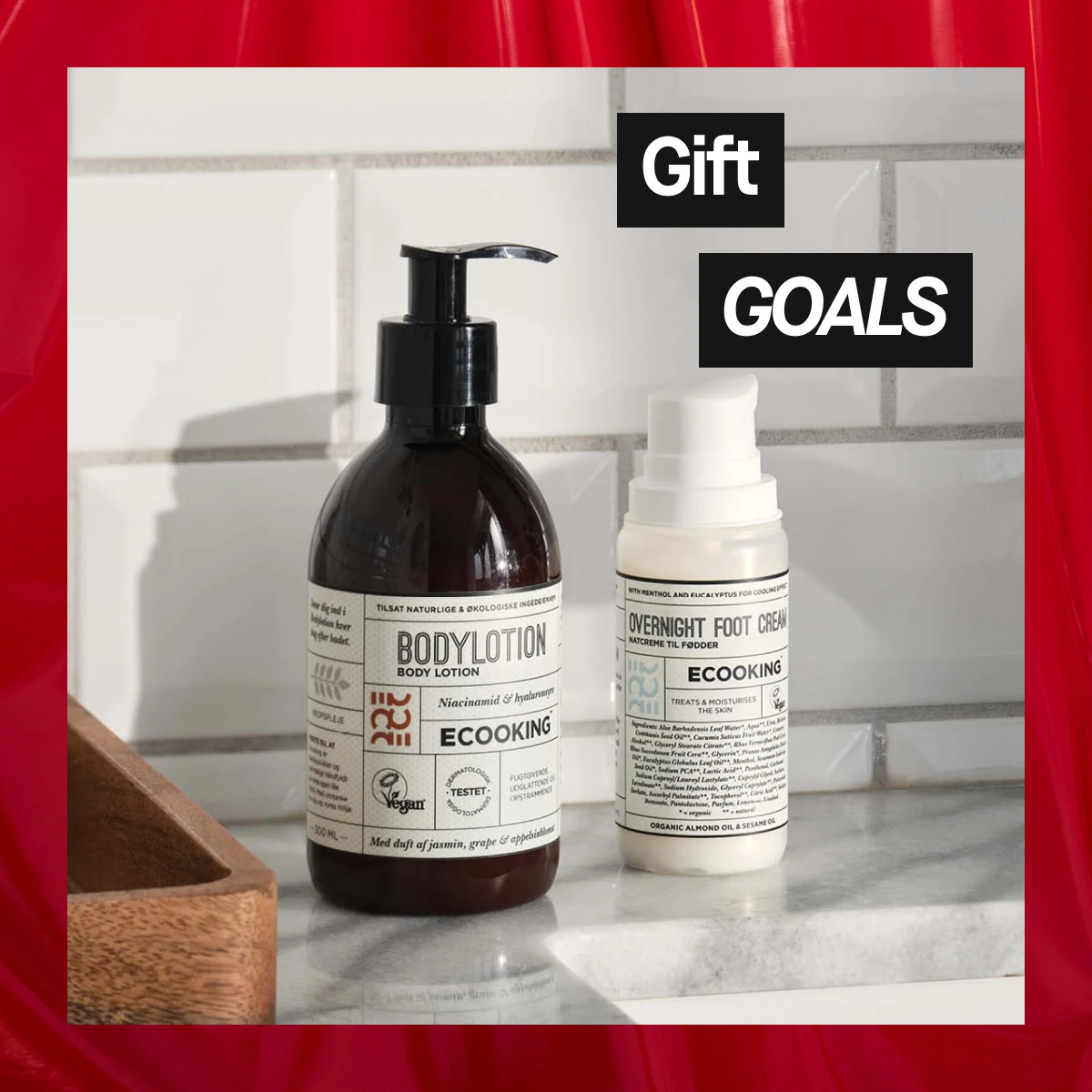 Bild som visar två Ecooking produkter: Body Lotion och Overnight Foot Cream. Texten "Gift GOALS" är synlig. Bakgrunden är vit med röda detaljer.