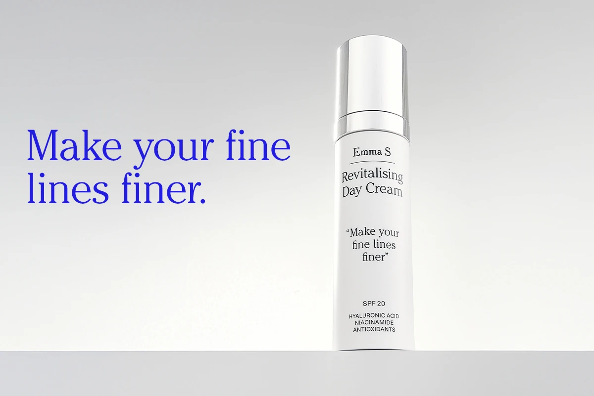 Flaske med ansiktskrem fra Emma S med teksten “Revitalising Day Cream”, “Make your fine lines finer”, “SPF 20”, “Hyaluronic Acid”, “Niacinamide” og “Antioxidants”, ved siden av teksten “Make your fine lines finer.” på en lys bakgrunn.
