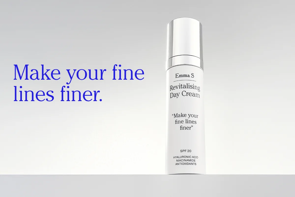 Flaske med ansiktskrem fra Emma S med teksten “Revitalising Day Cream”, “Make your fine lines finer”, “SPF 20”, “Hyaluronic Acid”, “Niacinamide” og “Antioxidants”, ved siden av teksten “Make your fine lines finer.” på en lys bakgrunn.