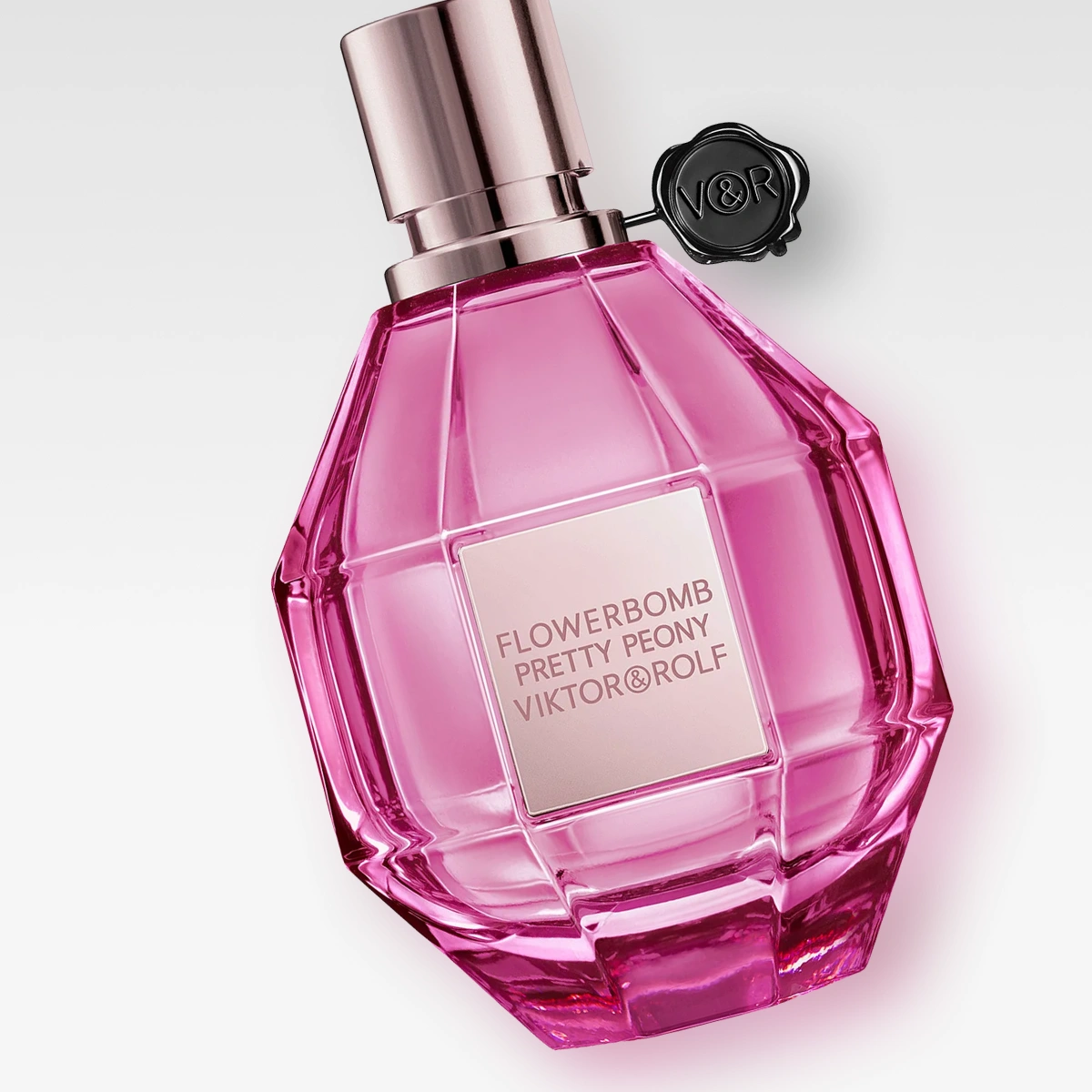 Viktor & Rolf Flowerbomb Pretty Peony parfymeflaske i rosa design med tekst på etiketten.