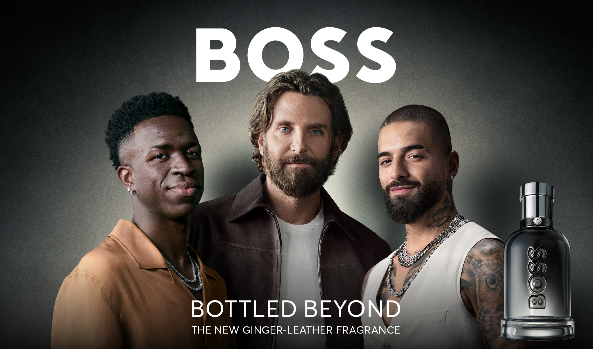 Tre män står framför BOSS-flaskor. Texten "BOTTLED BEYOND THE NEW GINGER-LEATHER FRAGRANCE" syns längst ner.
