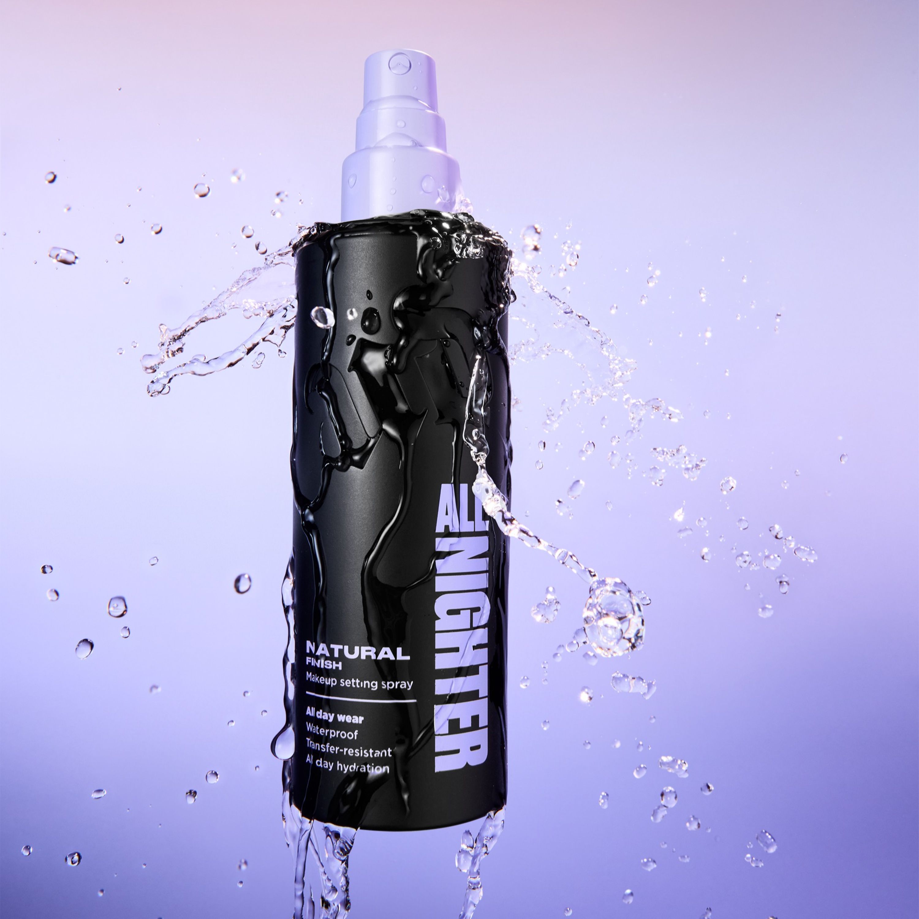 Person med fargerik øyemakeup i lilla og blått holder Urban Decay All Nighter setting spray i svart flaske med lilla spraypumpe mot blå bakgrunn. På flasken vises teksten “ALL NIGHTER”.