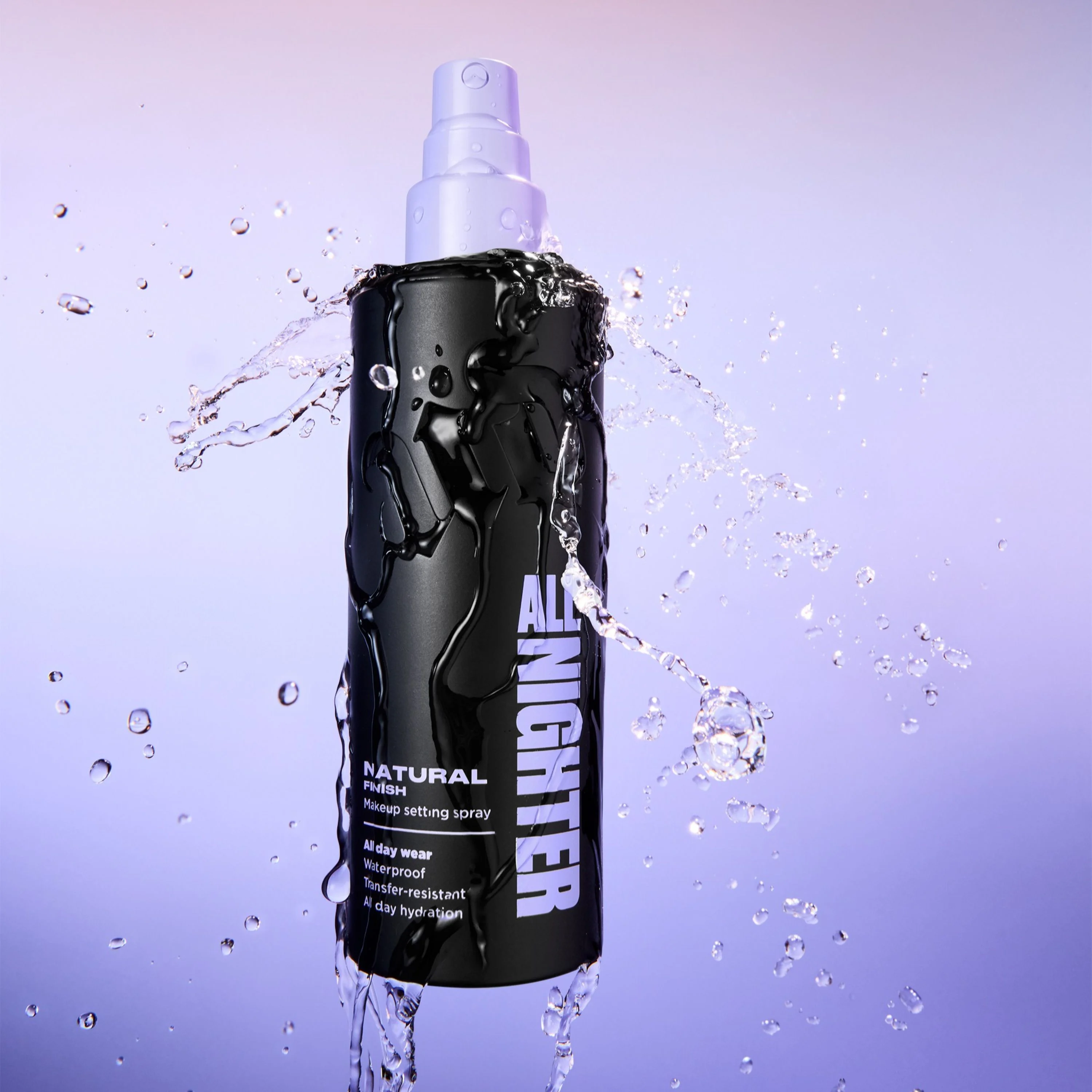 Person med fargerik øyemakeup i lilla og blått holder Urban Decay All Nighter setting spray i svart flaske med lilla spraypumpe mot blå bakgrunn. På flasken vises teksten “ALL NIGHTER”.
