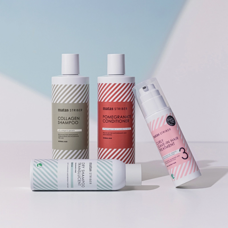 Matas Striber hiustenhoitotuotteet. Neljä pulloa: Collagen Shampoo, Pomegranate Conditioner, Curly Leave-In Hair Treatment ja Dry Shampoo Translucent. Pulloissa on raidallinen etiketti eri väreissä.