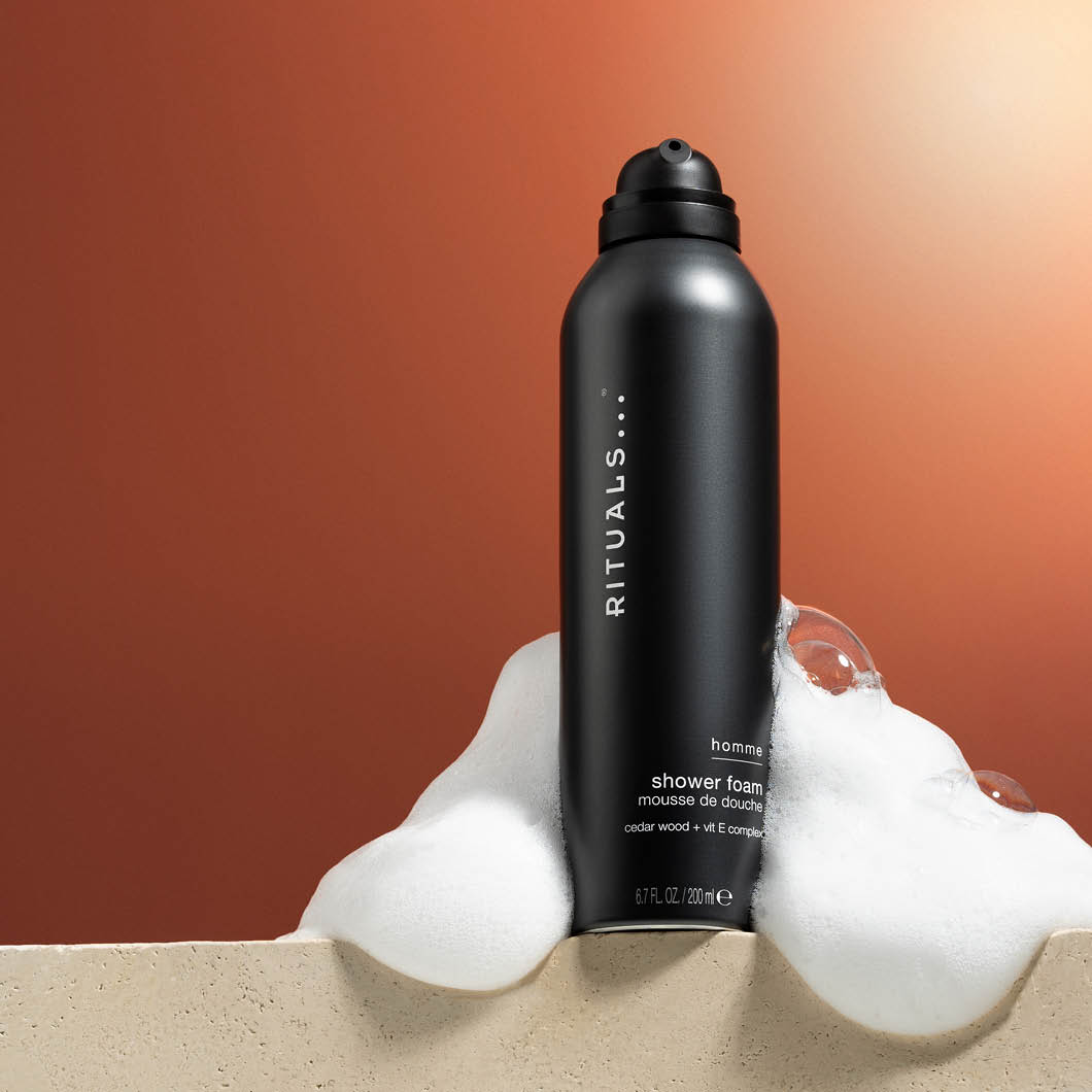  Rituals dusjskum for menn med synlig skum på brun bakgrunn.