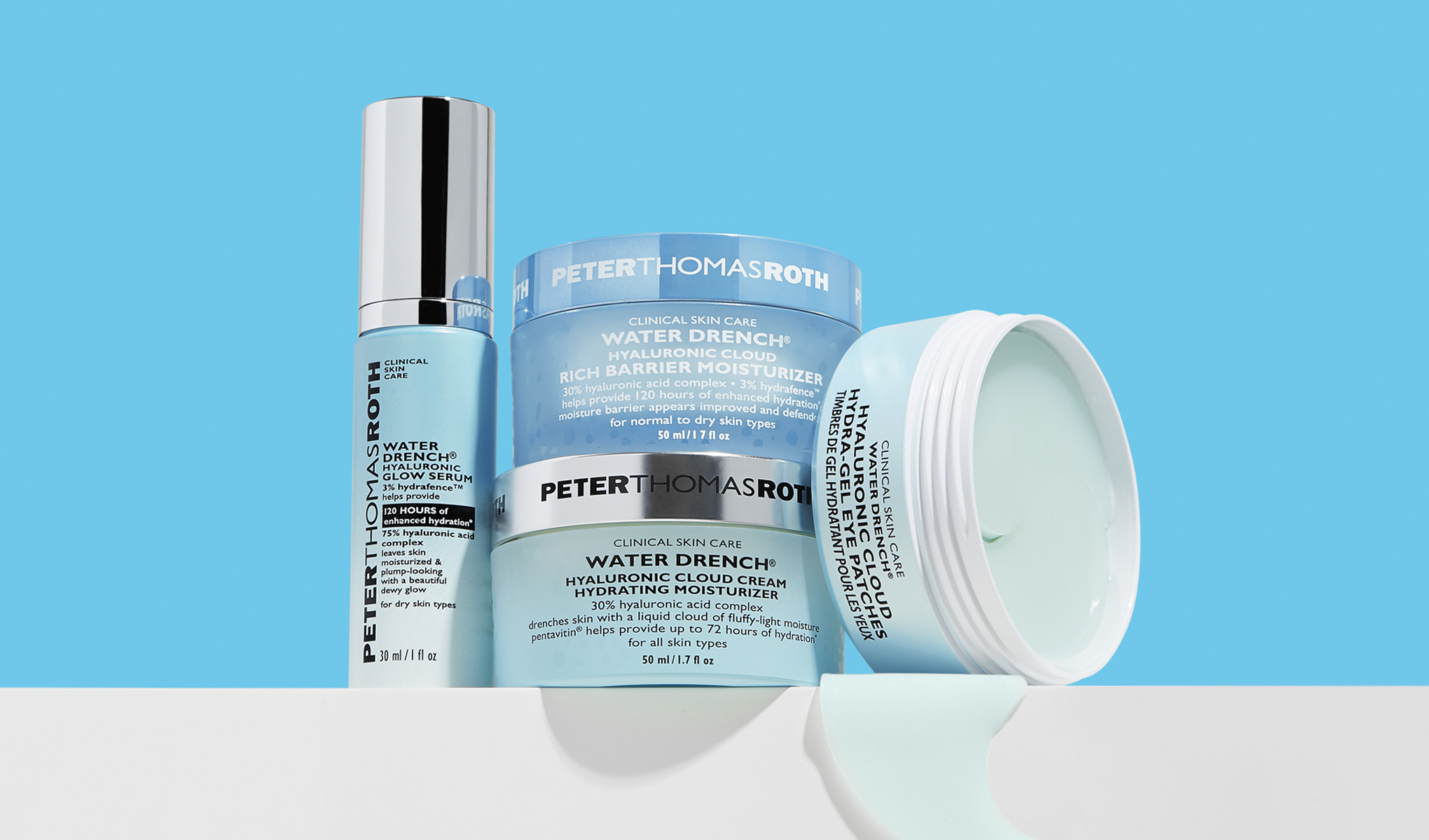 Peter Thomas Roth -ihonhoitotuotteita, kuten seerumi ja voiteet, aseteltuna vaalealle alustalle sinistä taustaa vasten.
