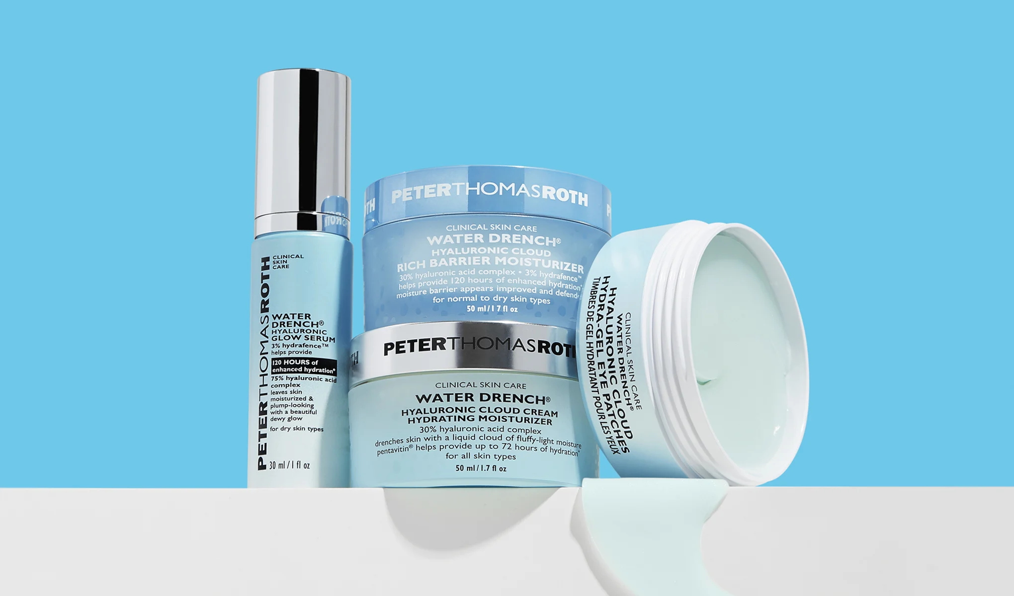 Peter Thomas Roth -ihonhoitotuotteita, kuten seerumi ja voiteet, aseteltuna vaalealle alustalle sinistä taustaa vasten.
