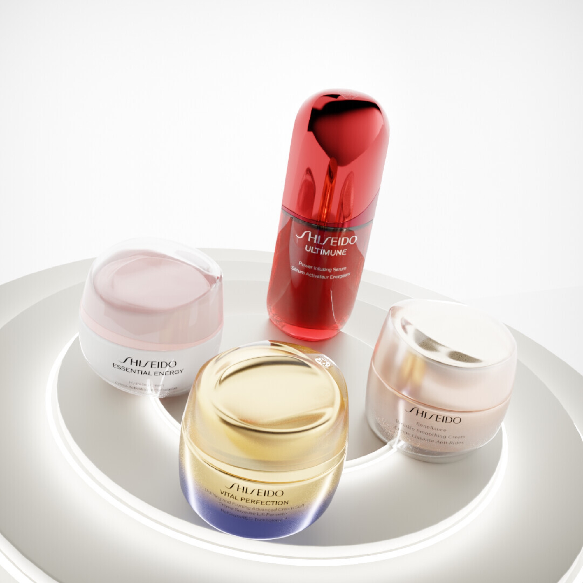 Flere Shiseido hudpleieprodukter, inkludert serum og kremer, arrangert på en rund overflate mot en lys bakgrunn.