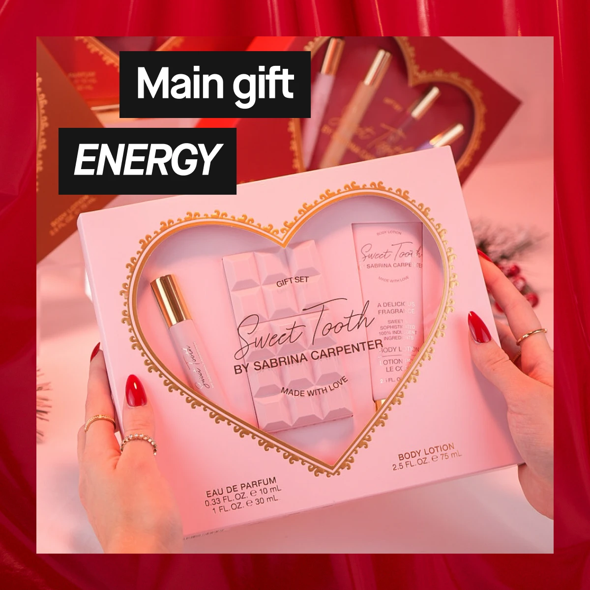 Bilde som viser en gaveeske med Sweet Tooth by Sabrina Carpenter. Teksten "Main gift ENERGY" er synlig. Bakgrunnen er rosa med røde detaljer.