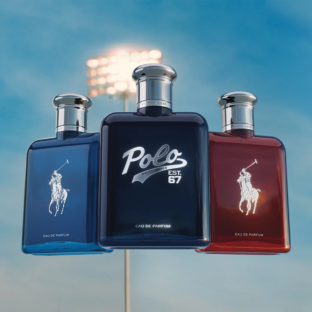 Tre parfymeflasker fra Ralph Lauren vises opp mot en himmel med en lyskaster i bakgrunnen. 