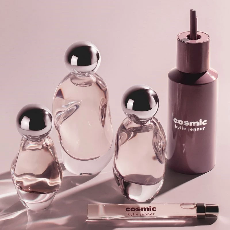 Erilaisia hajuvesiä Kylie Cosmeticsilta vaaleanpunaisella taustalla.