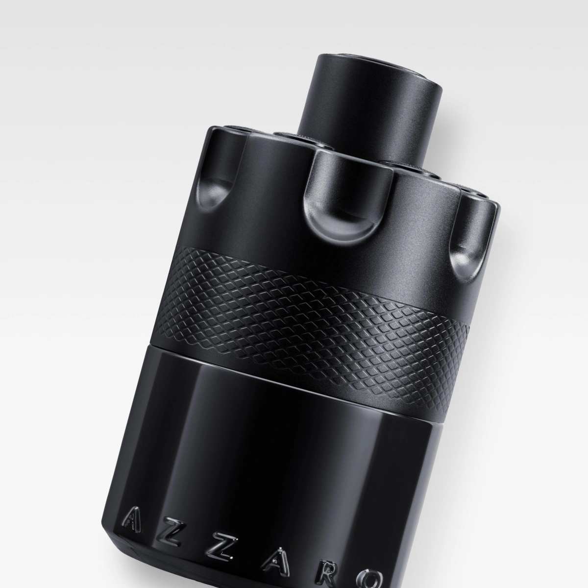 Azzaro parfymeflaske i svart design med teksten "AZZARO" på flasken.