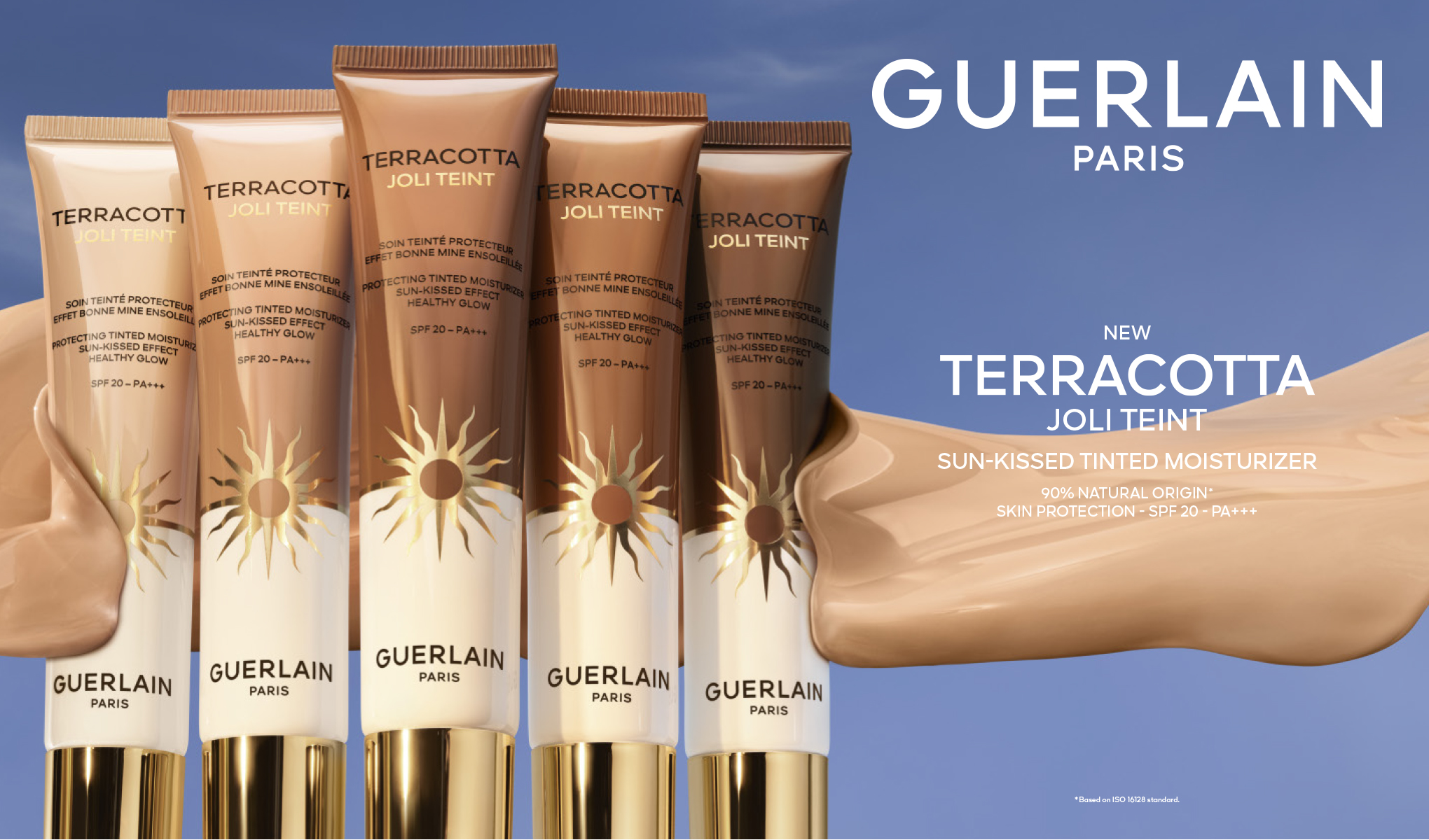 Guerlain Terracotta Joli Teint solkysset farget dagkrem med SPF 20 og PA+++; fem tuber i ulike nyanser står ved siden av en kremtekstur mot blå bakgrunn, teksten «NEW» vises i bildet.