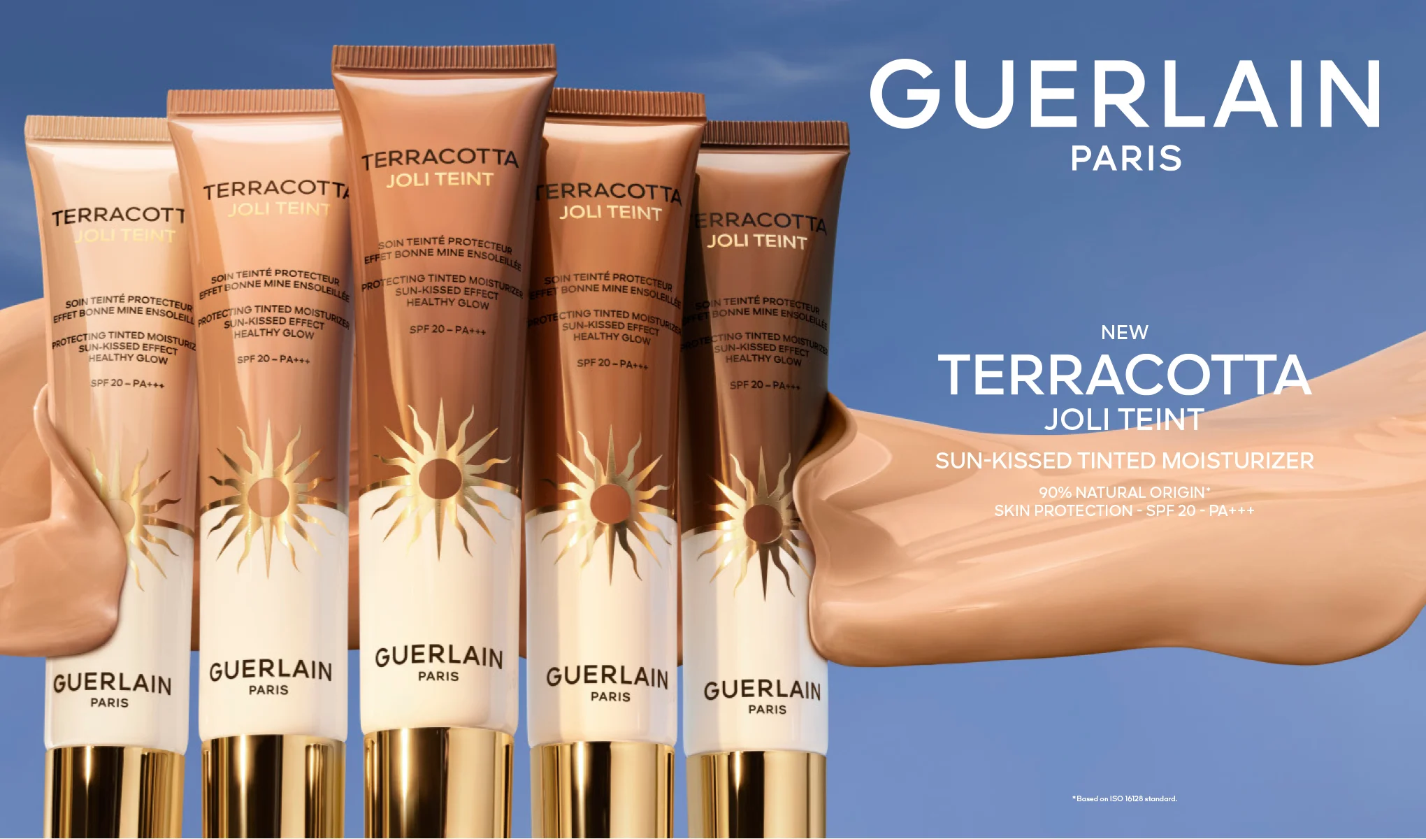 Guerlain Terracotta Joli Teint solkysset farget dagkrem med SPF 20 og PA+++; fem tuber i ulike nyanser står ved siden av en kremtekstur mot blå bakgrunn, teksten «NEW» vises i bildet.