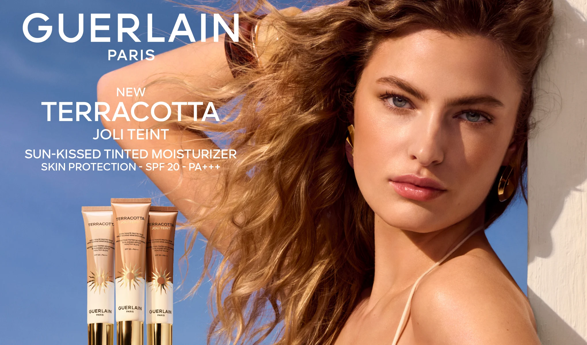 Guerlain Terracotta Joli Teint solkysst färgad dagkräm med SPF 20 och PA+++; tre tuber visas tillsammans med en modell i soligt ljus mot blå bakgrund, texten ”NEW” finns i bilden.