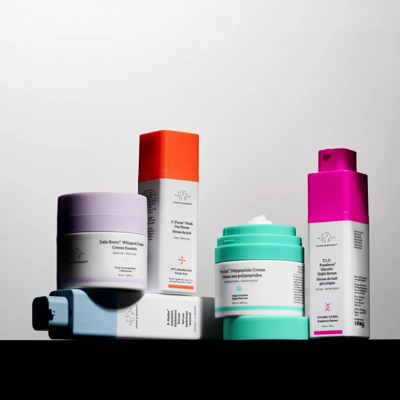 Drunk Elephant-hudpleieprodukter foran lys bakgrunn, inkludert kremer og serum.