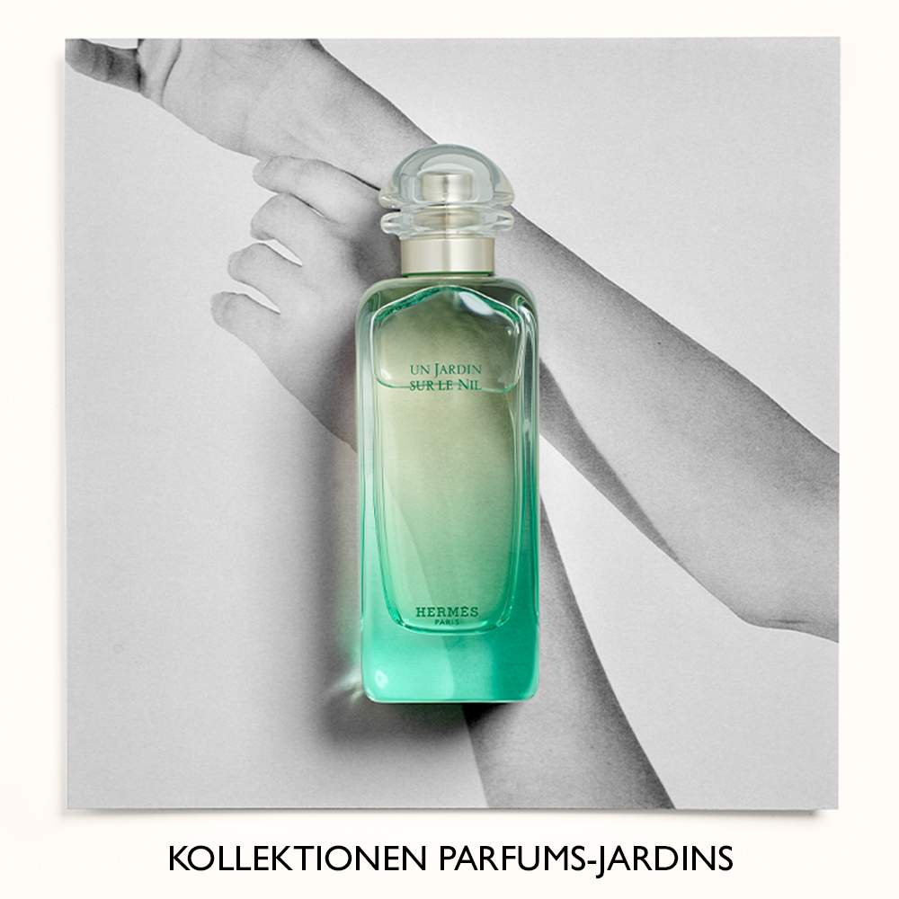 Parfymflaska från Hermès, Un Jardin Sur Le Nil, placerad framför en svartvit bild av armar. Texten "Kollektionen Parfums-Jardins" syns längst ner.