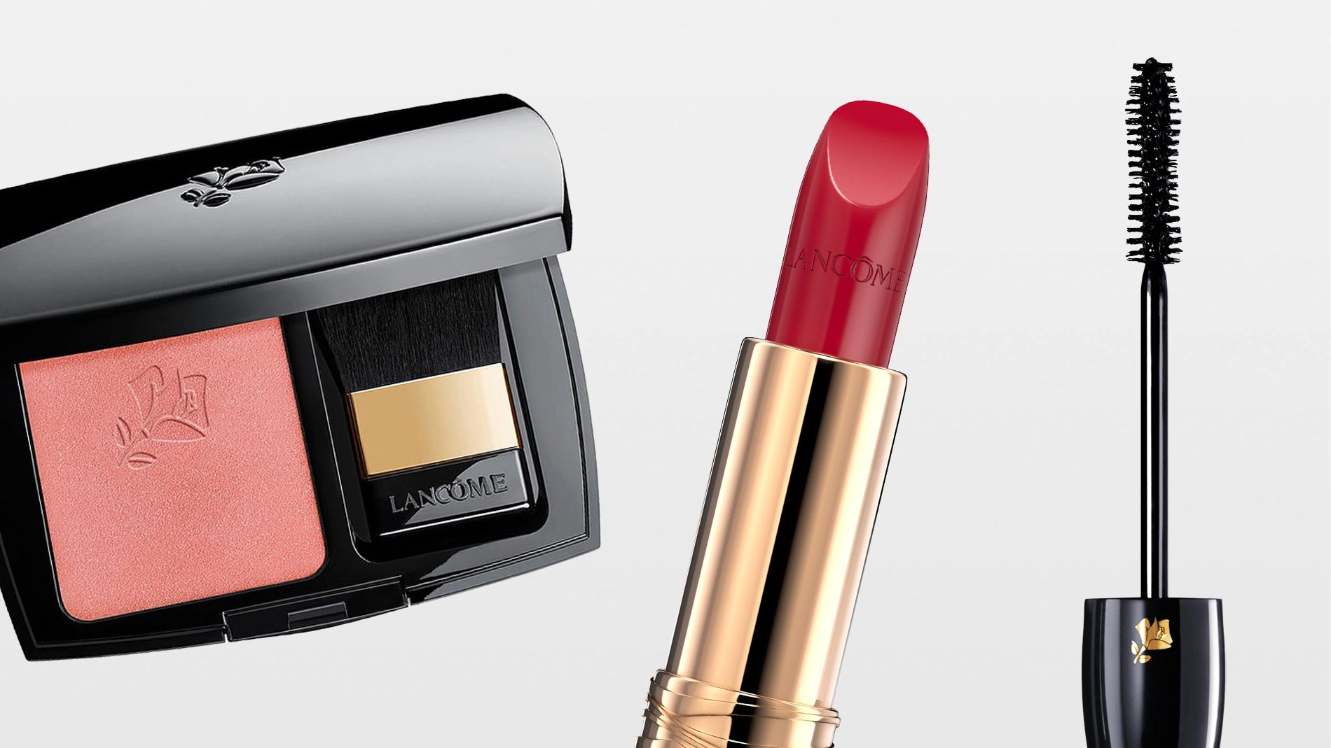 Lancôme makeup med rosa rouge i en svart dosa med spegel och rougeborste, rött läppstift i guldfärgad hylsa samt mascara med borste. Varumärket Lancôme syns på förpackningarna för sminkprodukterna rouge, lipstick och mascara.