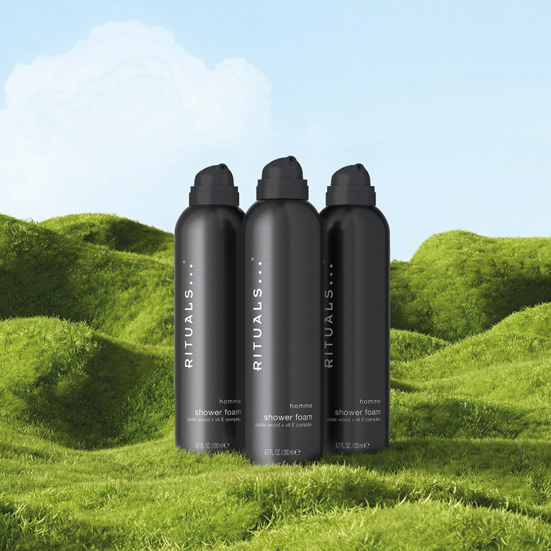 Tre Rituals The Ritual of Sakura dusjgeléflasker på grønt gress med blå himmel i bakgrunnen.