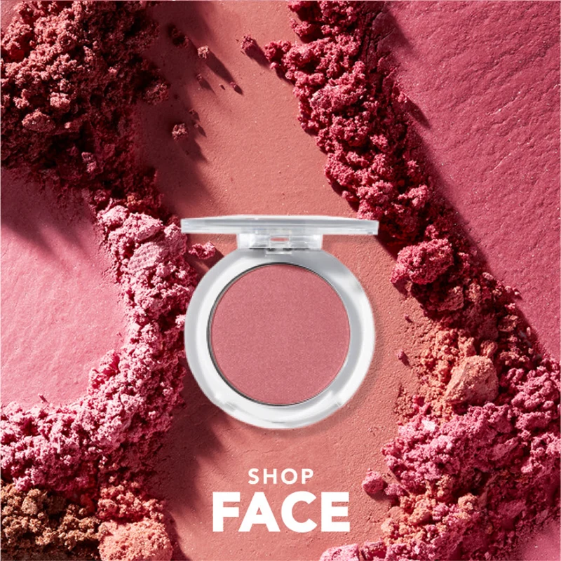Rosa rougekompakt på strødd pudder. Tekst: SHOP FACE.
