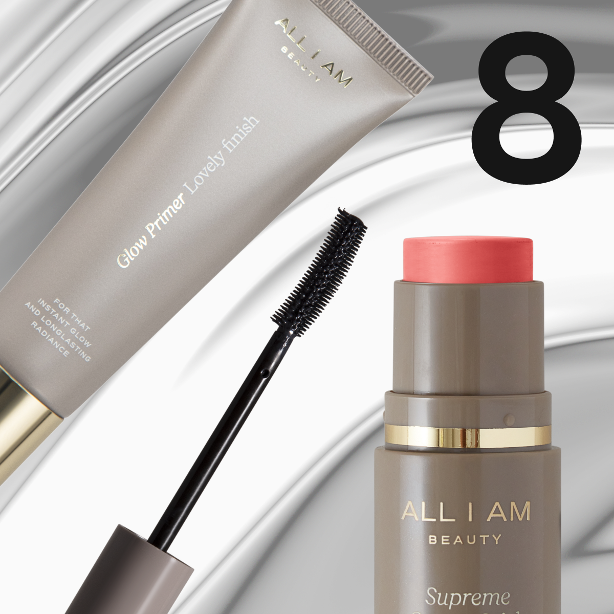 Bilde som viser en grå tube med ALL I AM Beauty Primer Lovely Finish, en svart mascara børste, og en grå flaske med ALL I AM Beauty blush. Bakgrunnen er grå med hvite detaljer.