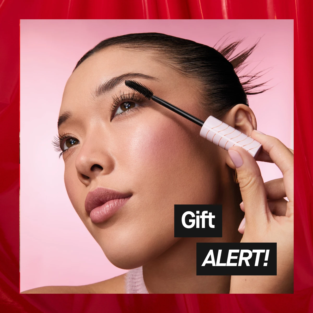 Närbild på en person som håller en vit applikator vid örat. Bakgrunden är rosa.