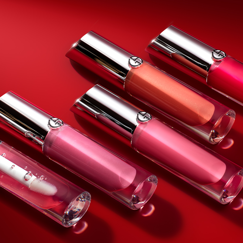 Lipgloss fra Giorgio Armani i ulike nyanser av rosa, rød og oransje. Lipglossenes emballasje har sølvfargede hetter med Giorgio Armanis logo. Bakgrunnen er intens rød.