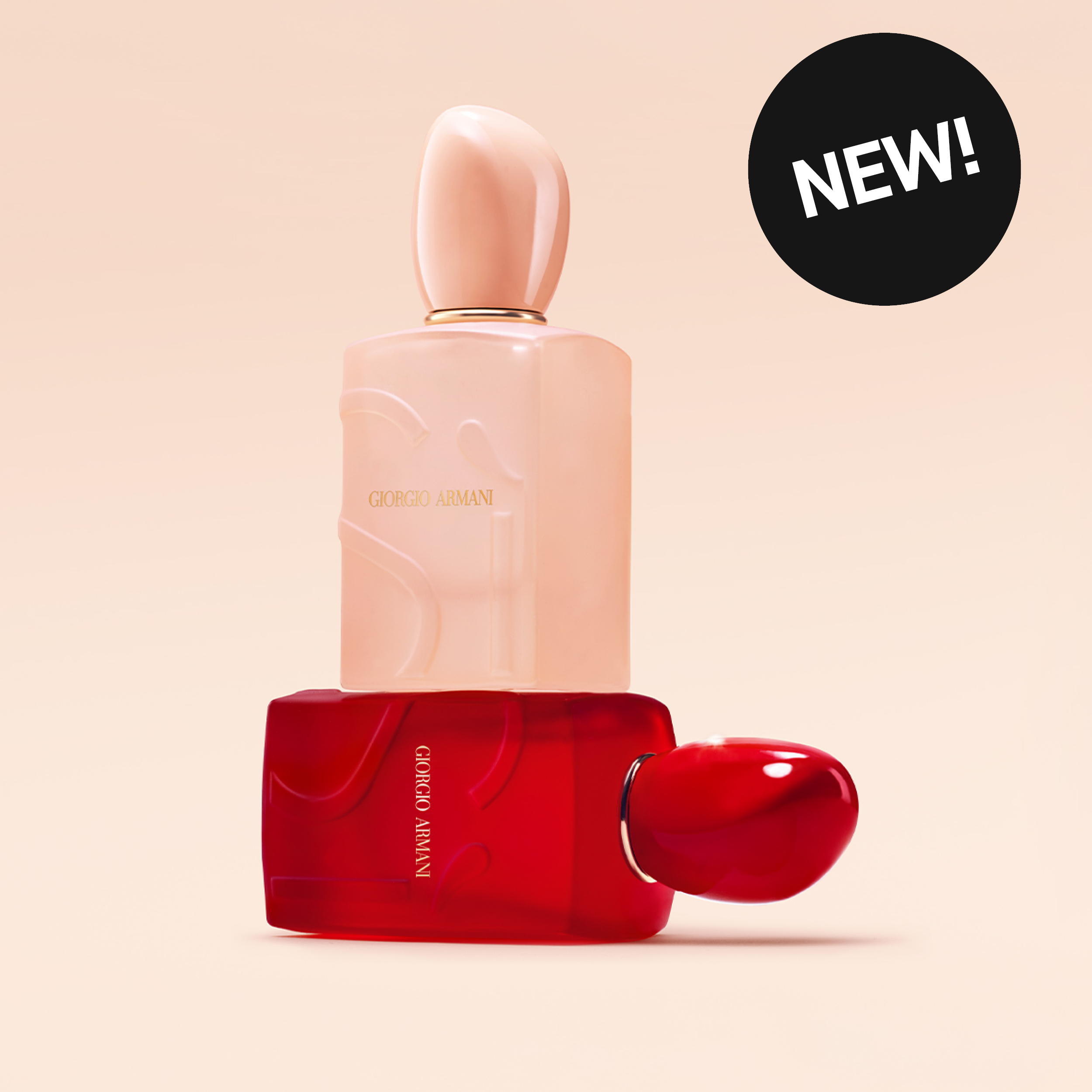 Kaksi Giorgio Armani -parfyymipulloa punaisessa ja puuteriroosassa sävyssä beigeä taustaa vasten. Kuvassa näkyy tekstit “NEW!” ja Giorgio Armani sekä kiiltäväpintaiset koristeelliset pullot.