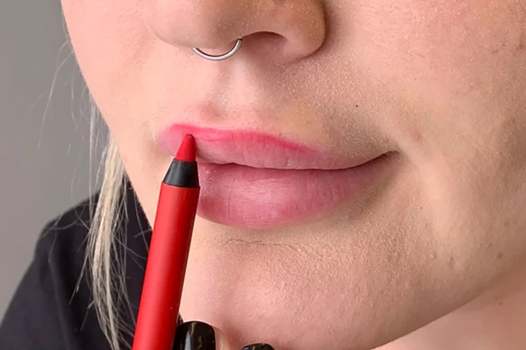 Läpparna är markerade med en röd lipliner.