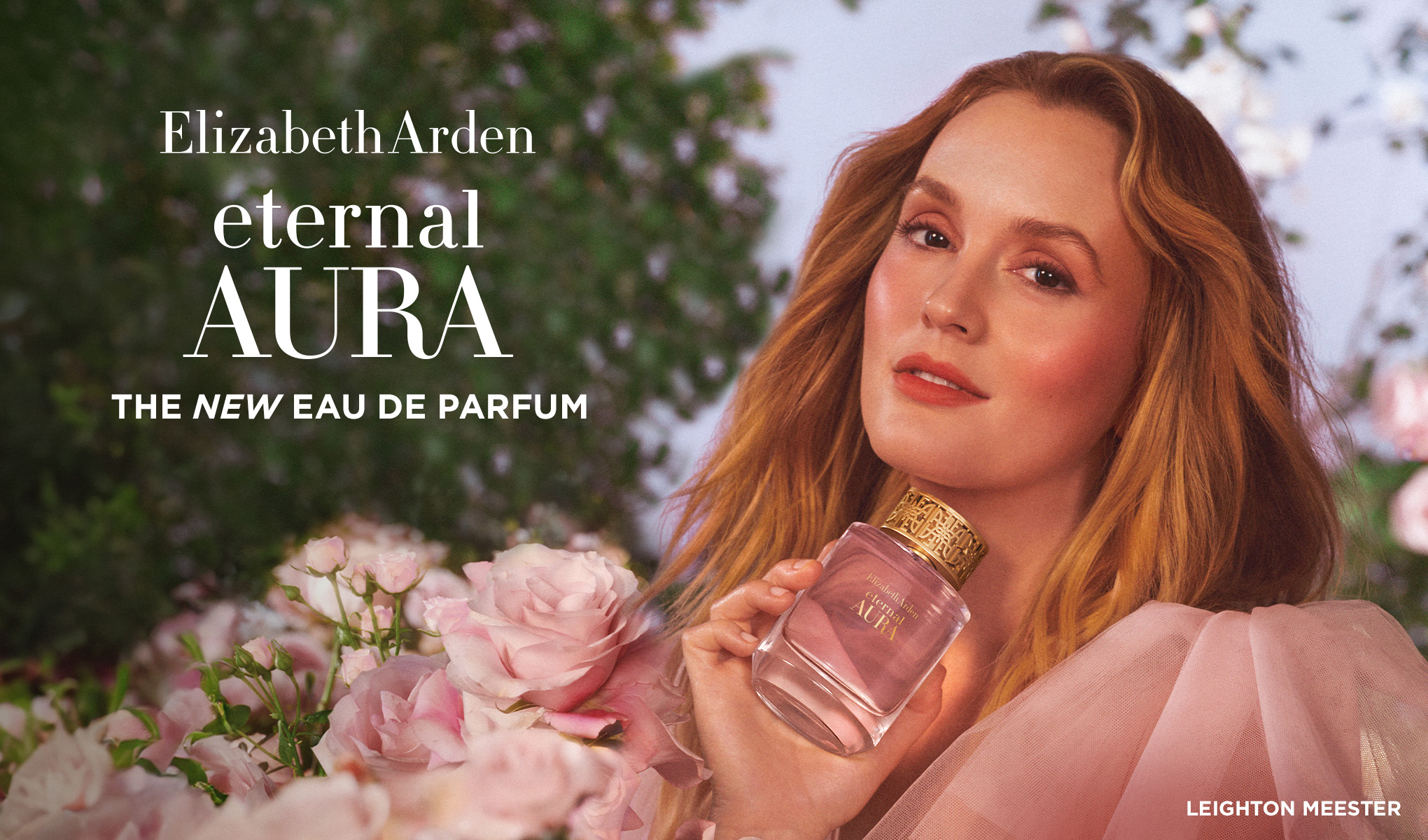 Person håller Elizabeth Arden Eternal Aura-parfym bland rosa blommor, med texten ”The New Eau de Parfum”.