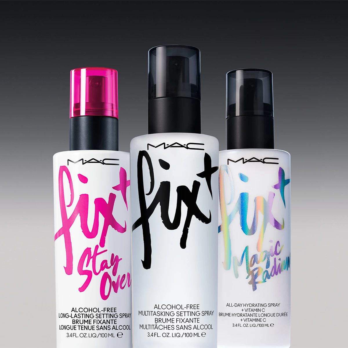 Tre olika setting sprays från MAC Cosmetics står uppradade mot en mörkgrå bakgrund. Alla flaskor har vita förpackningar med text på.