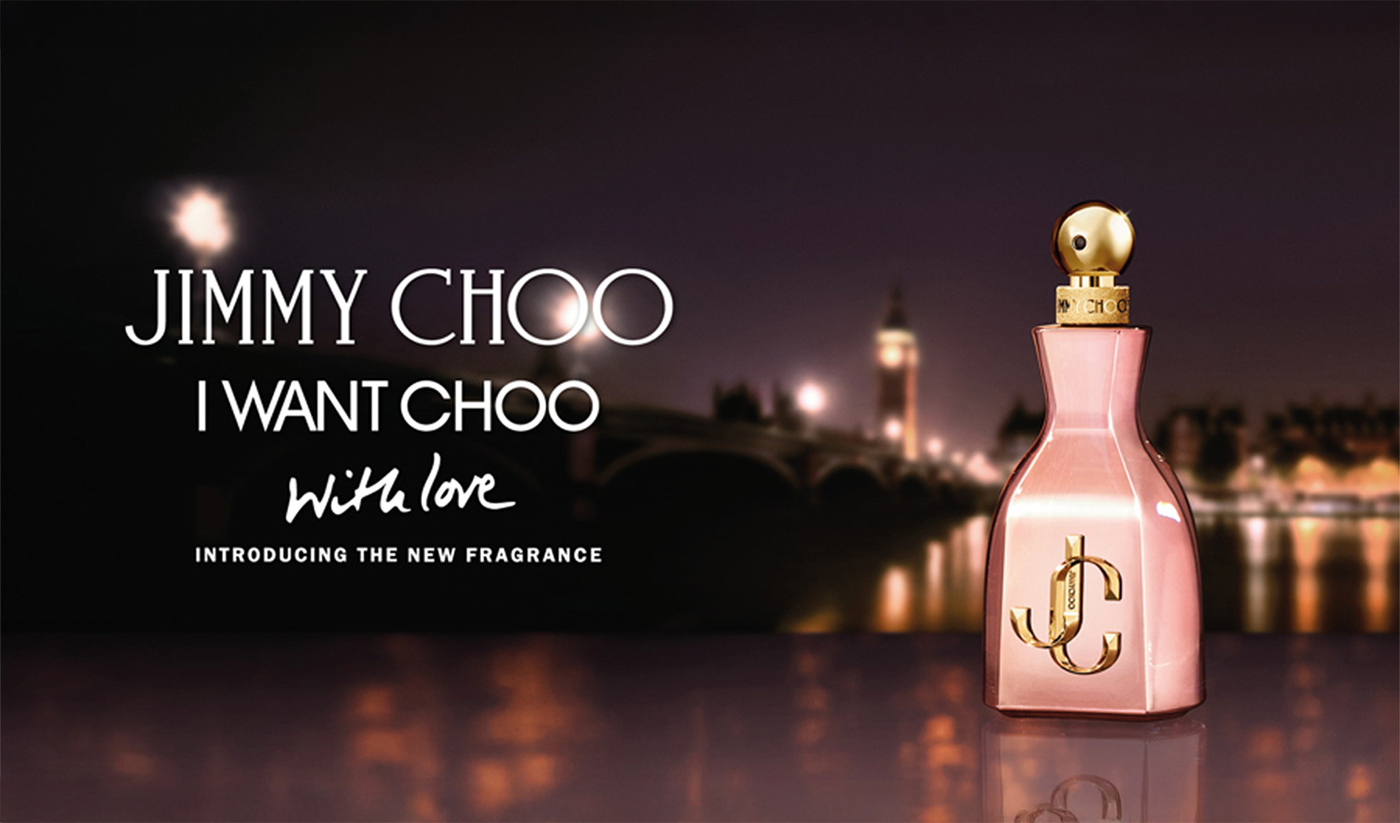 Jimmy Choo-parfymflaskan är placerad framför ett glödande nattlandskap. I bakgrunden syns stadens siluett och ljus, vilket skapar en romantisk atmosfär.