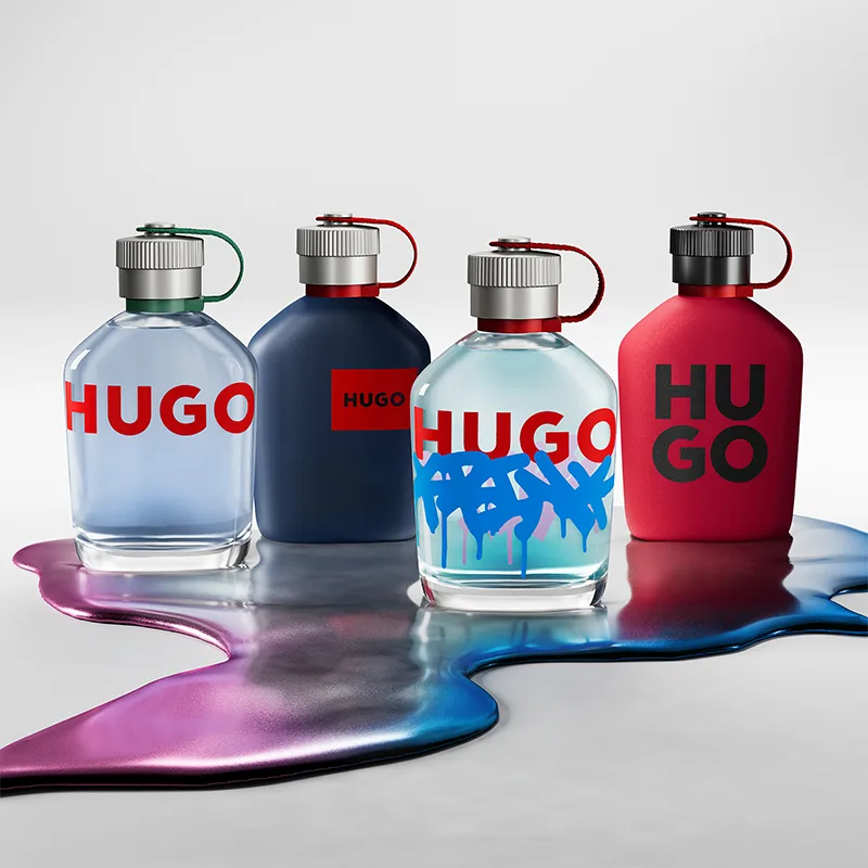Hugo-parfymeflasker i ulike farger plassert på fargerik væske.
