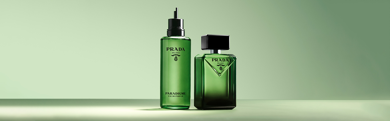 To grønne Prada Paradigme-parfymeflasker på en lysegrønn bakgrunn.