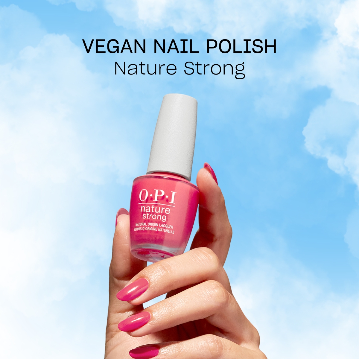 Käsi, jossa on OPI-merkin vaaleanpunainen kynsilakka. Kädessä on kynsilakkapullo nimeltä ”Nature Strong”. Taustalla on sininen taivas, jossa on valkoisia pilviä, ja kynsilakkapullon yläpuolella on teksti ”Vegan Nail Polish Nature Strong”.