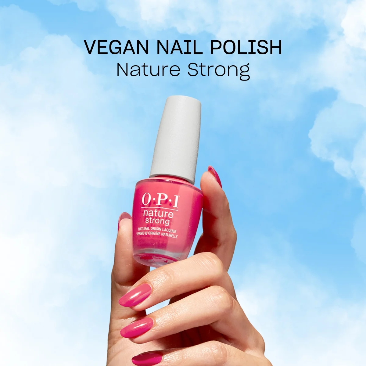 Käsi, jossa on OPI-merkin vaaleanpunainen kynsilakka. Kädessä on kynsilakkapullo nimeltä ”Nature Strong”. Taustalla on sininen taivas, jossa on valkoisia pilviä, ja kynsilakkapullon yläpuolella on teksti ”Vegan Nail Polish Nature Strong”.