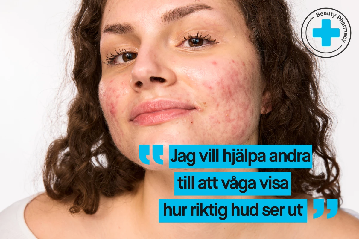 En person med lockigt hår och vit tröja.