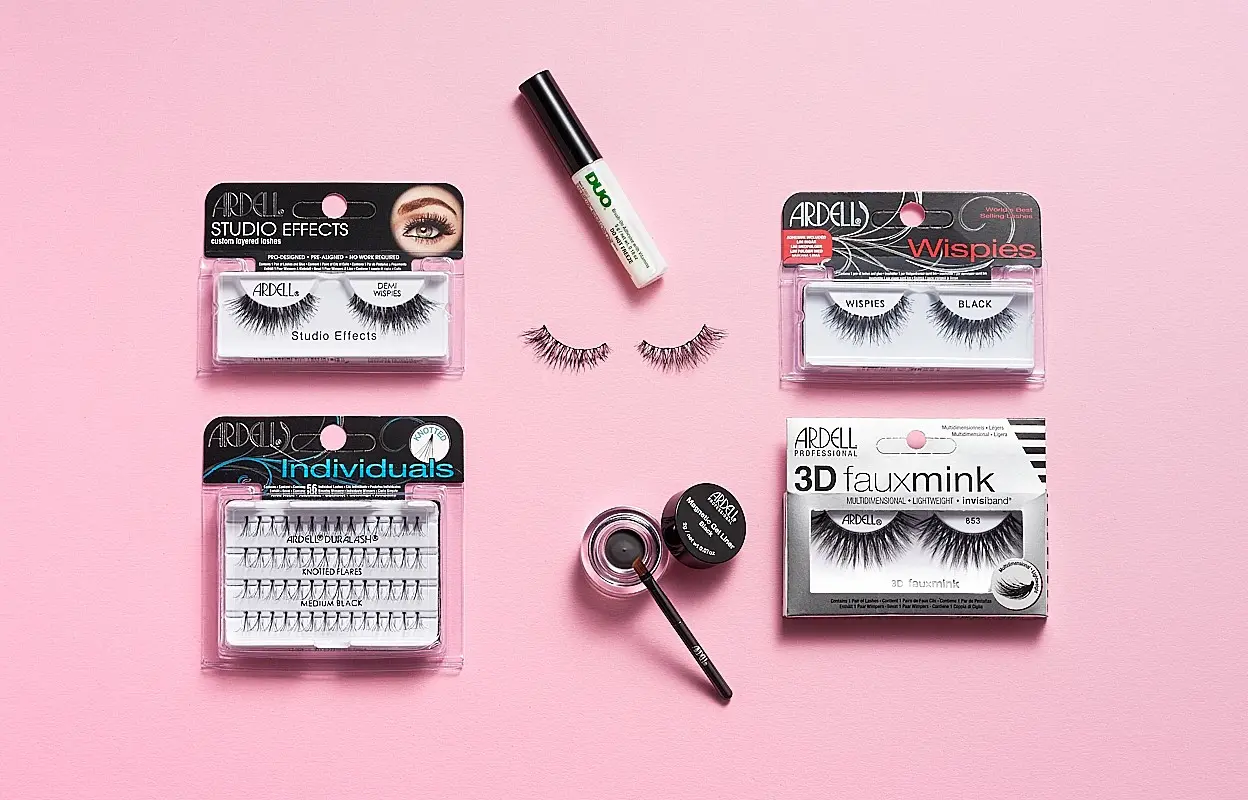 Ögonbryns- och lösögonfransprodukter från Ardell, inklusive Ardell Studio Effects Demi Wispies, Ardell Individuals Knot Flared Medium Black, Ardell Wispies Black, Ardell 3D Faux Mink, DUO ögonfranslim och Ardell Brow Pomade med borste. Produkterna är placerade på en rosa bakgrund.