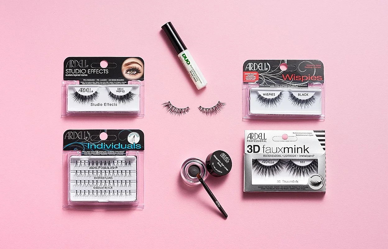 Ögonbryns- och lösögonfransprodukter från Ardell, inklusive Ardell Studio Effects Demi Wispies, Ardell Individuals Knot Flared Medium Black, Ardell Wispies Black, Ardell 3D Faux Mink, DUO ögonfranslim och Ardell Brow Pomade med borste. Produkterna är placerade på en rosa bakgrund.