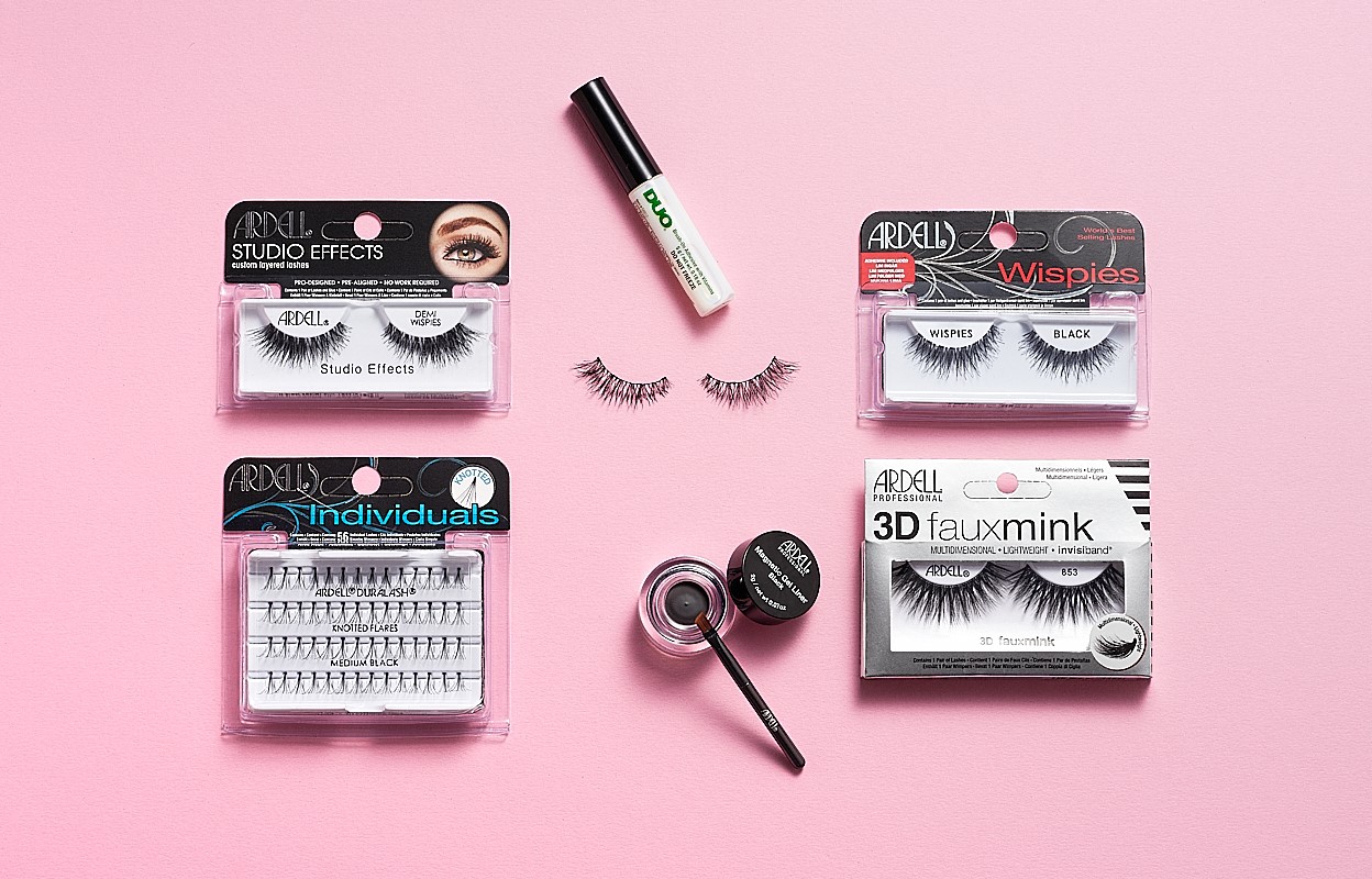 Kuva useista Ardellin kulmakarvojen ja tekoripsien tuotteista, mukaan lukien Ardell Studio Effects Demi Wispies, Ardell Individuals Knot Flared Medium Black, Ardell Wispies Black, Ardell 3D Faux Mink, DUO-ripsiliima ja Ardell Brow Pomade harjalla. Tuotteet on sijoitettu vaaleanpunaiselle taustalle.