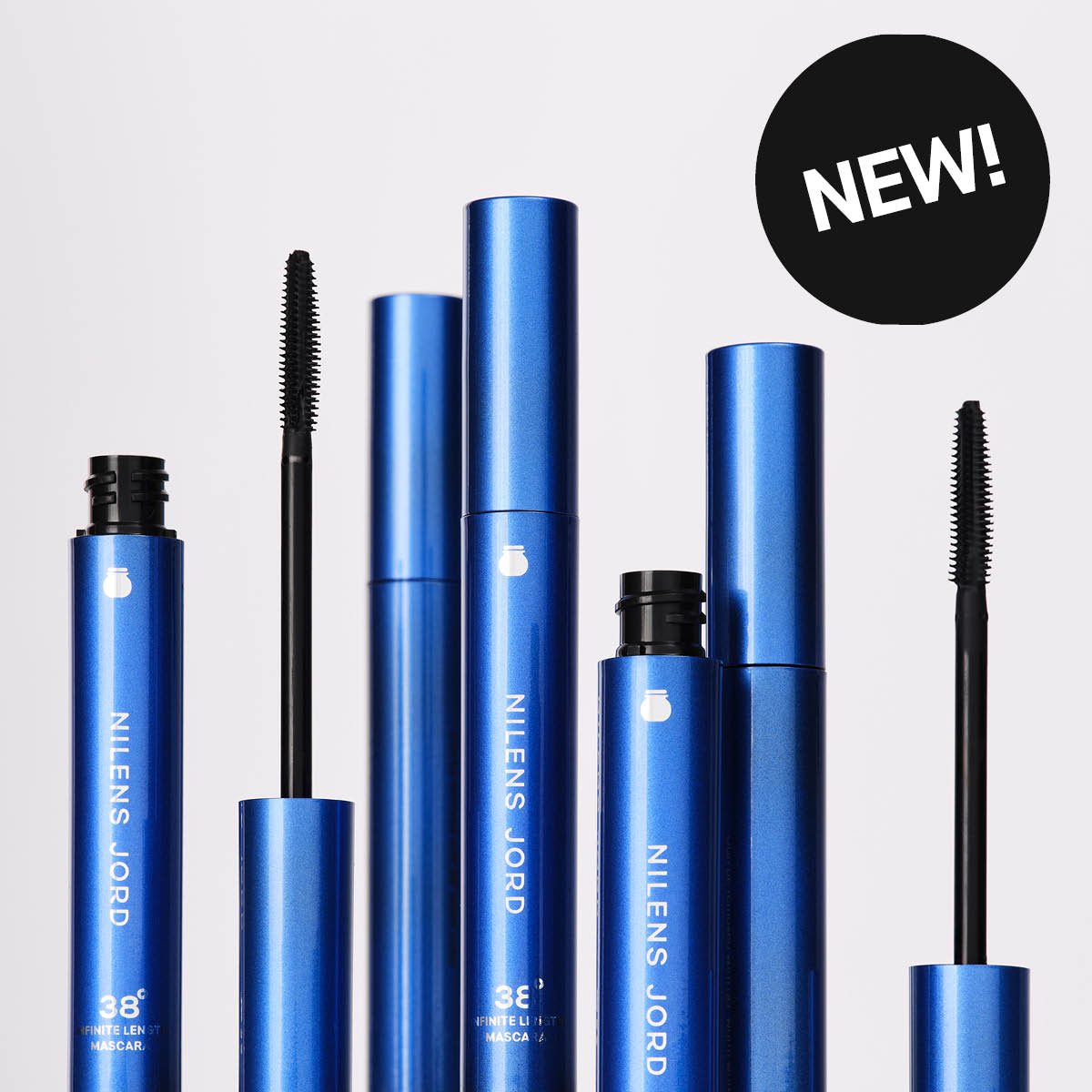 Useita sinisiä ripsivärejä harjoilla merkiltä Nilens Jord, teksti “NILENS JORD 38° INFINITE LENGTH MASCARA” sekä musta ympyrä, jossa lukee “NEW!”.