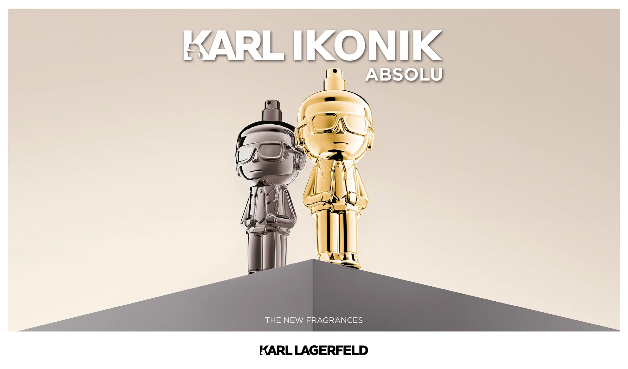 Karl Lagerfeld Ikonik Absolu-parfymer i to flasker, sølv og gull, formet som Karl Lagerfeld-figurer på en sokkel mot en lys bakgrunn.