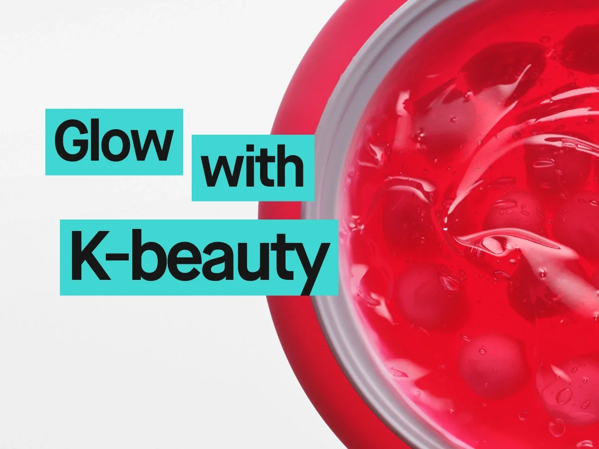 Nærbilde av rød geltekstur i en åpen krukke med teksten "Glow with K-beauty". Bildet fremhever K-beauty og hudpleie med fokus på produkter som gir glød.