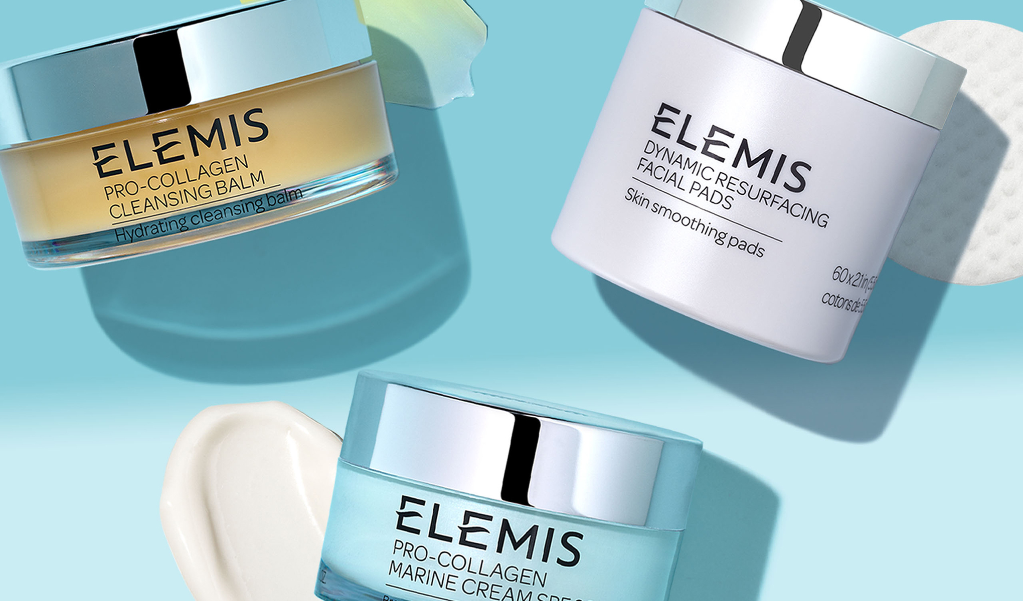 Tre hudpleieprodukter fra Elemis, satt på en lyseblå bakgrunn og elegant designet med sølvfargede lokk.