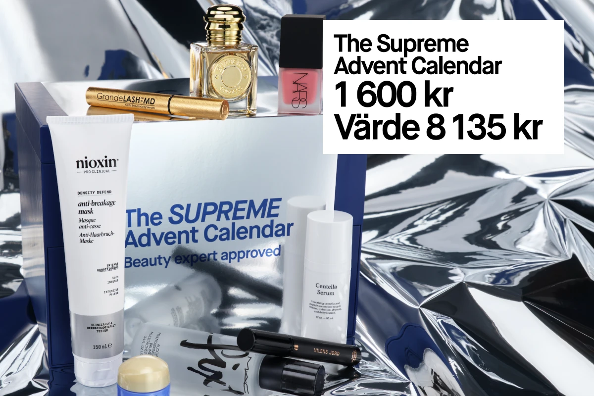 The Supreme Advent Calendar - 1 600 kr, värde 8 135 kr. Bilden visar en blå presentförpackning och olika kosmetikprodukter mot en silverfärgad bakgrund.