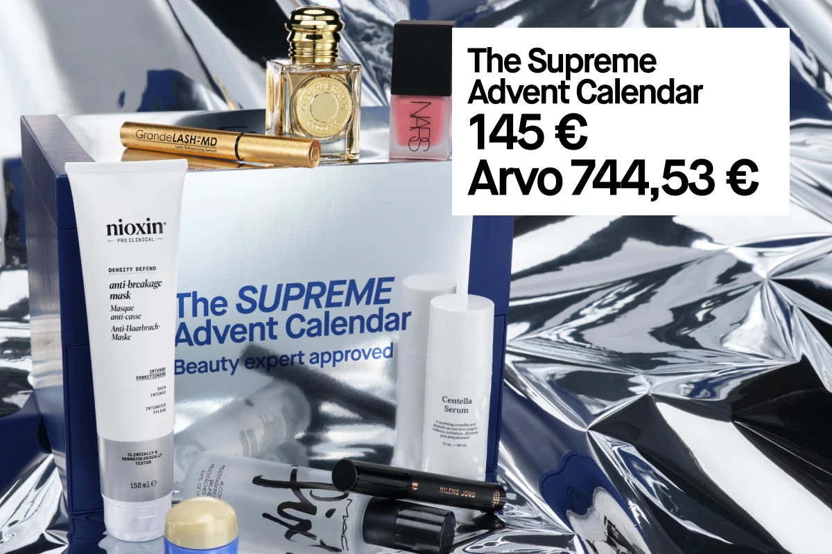 The Supreme Advent Calendar - 1 600 kr, arvo 8 135 kr. Kuvassa näkyy sininen lahjapakkaus ja erilaisia kosmetiikkatuotteita hopeisella taustalla.