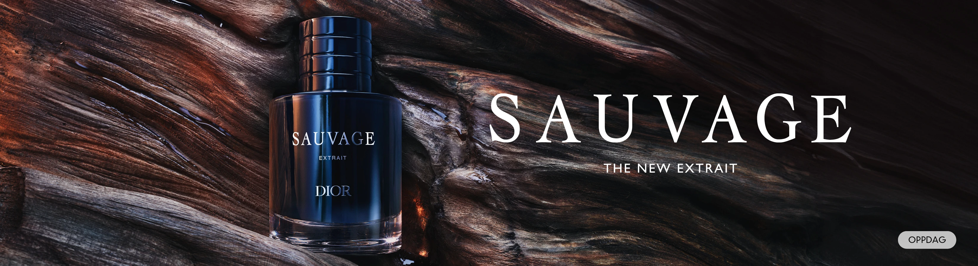 Dior Sauvage Extrait parfymeflaske på mørkt tre. Tekst: Sauvage, The New Extrait. Oppdag.