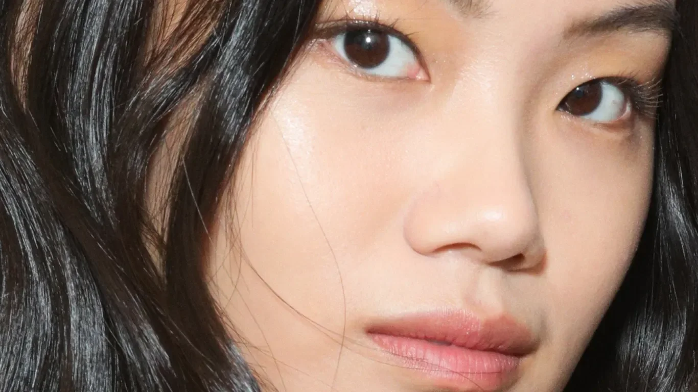 Nærbilde av en kvinne med glatt hud og mørkt hår.